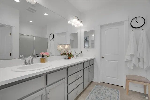 a bathroom with a double vanity sink a toilet and a mirror