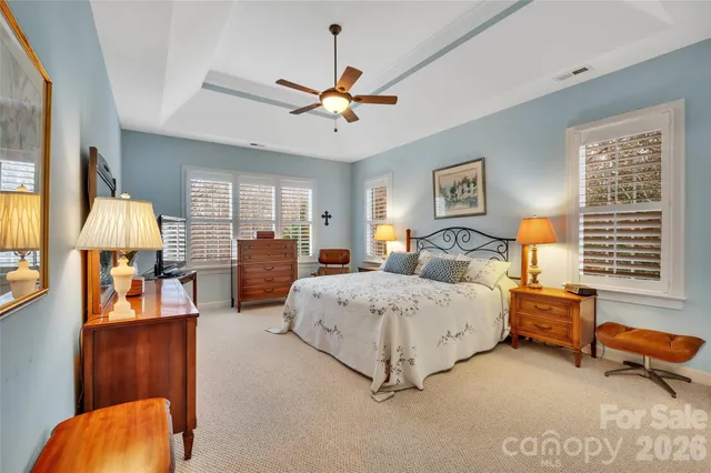 a spacious bedroom with a bed and wooden floor