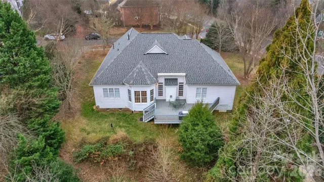 an aerial view of a house with a yard and large trees