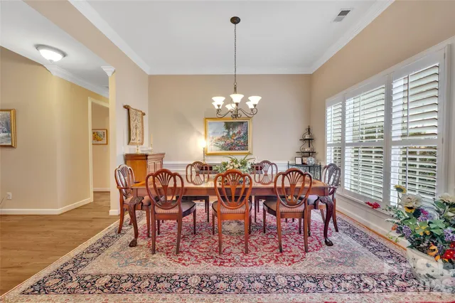 a dining room with furniture a rug and a chandelier