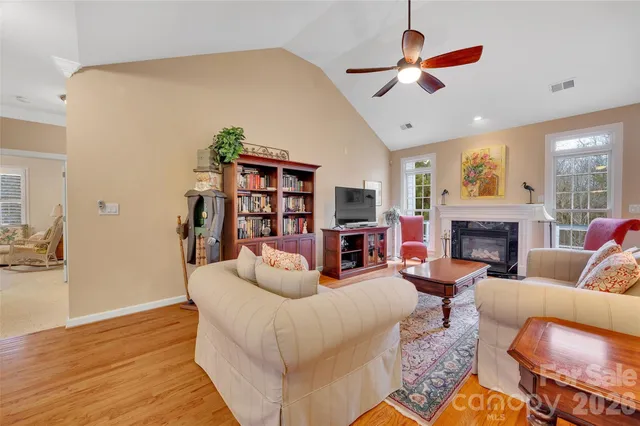 a living room with furniture a fireplace and a flat screen tv