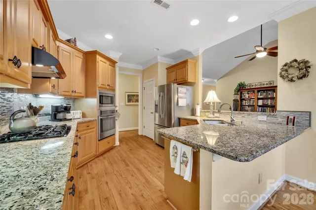 a kitchen with stainless steel appliances granite countertop a sink stove and refrigerator