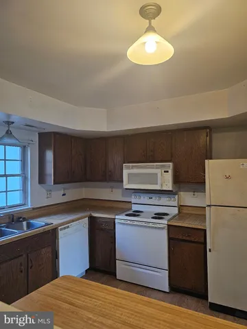 a kitchen with a refrigerator cabinets and wooden floor
