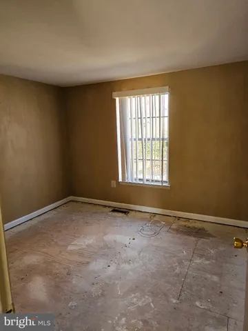 a view of a bedroom with a bed and wooden floor