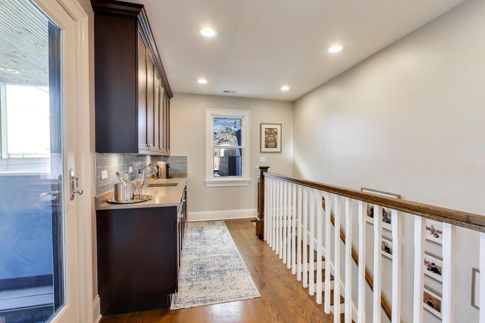 1428 West George Street Chicago, IL 60657 - Photo 33 of 66 a view of hallway with granite countertop lots of wooden cabinets