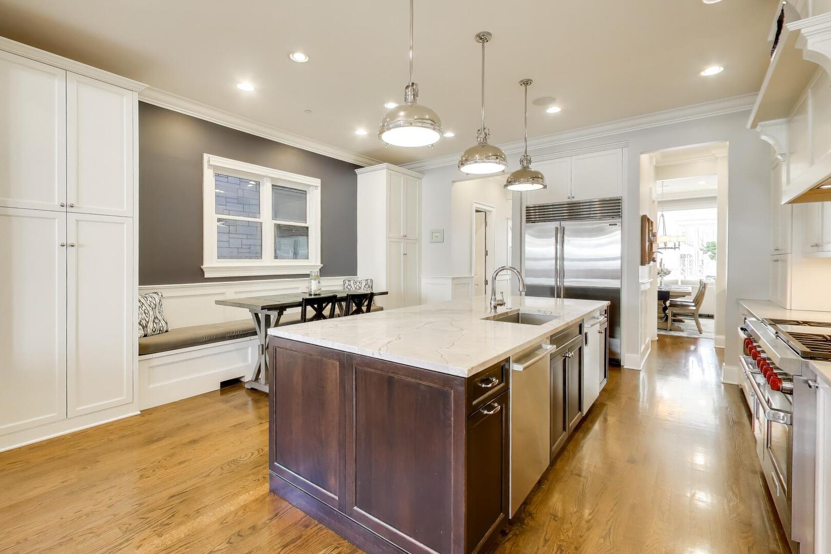 1428 West George Street Chicago, IL 60657 - Photo 7 of 66 a large kitchen with kitchen island a large island a sink stainless steel appliances and cabinets