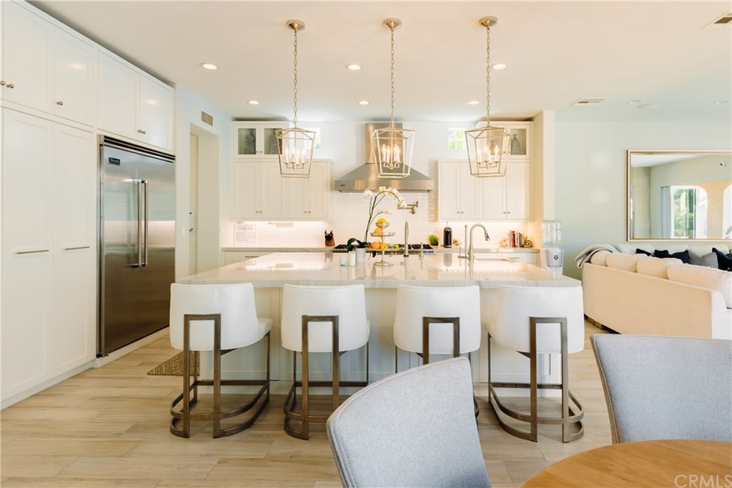 26 Seabluff Newport Beach, CA 92660 - Photo 12 of 59 a kitchen with white cabinets and chairs