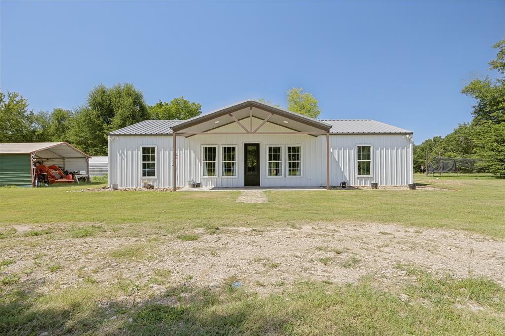 822 Private Road 7370 Point, TX 75472 - Photo 2 of 30 White metal siding structure with a covered entry, multiple windows, and a black front door