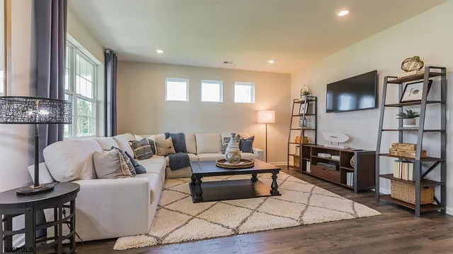 a living room with furniture a flat screen tv and kitchen view