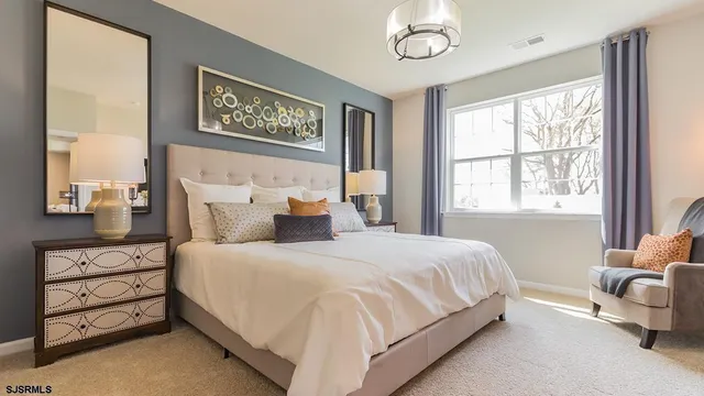 a bedroom with a bed a dresser next to a window