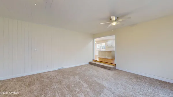 an empty room with chandelier fan