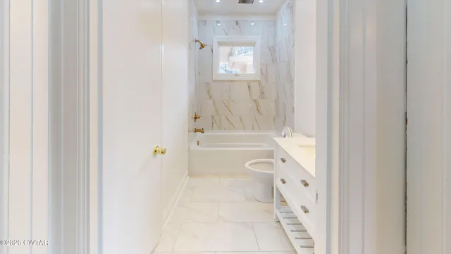 a bathroom with a granite countertop bathtub shower and a sink