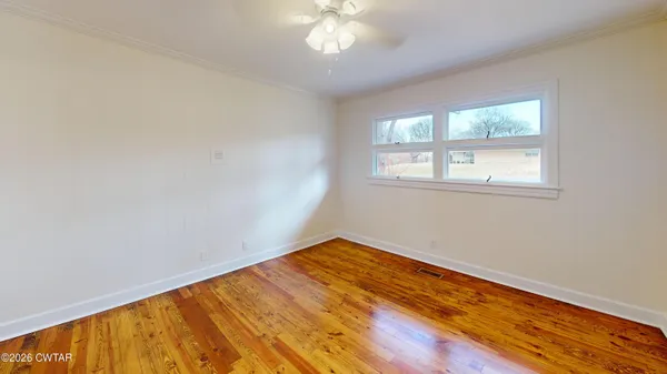 wooden floor in an empty room with a window