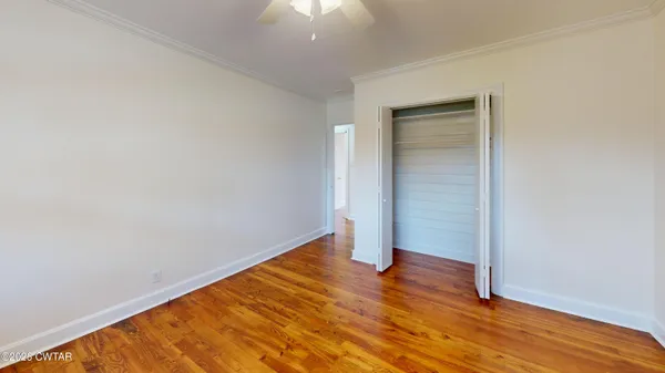 an empty room with wooden floor and closet