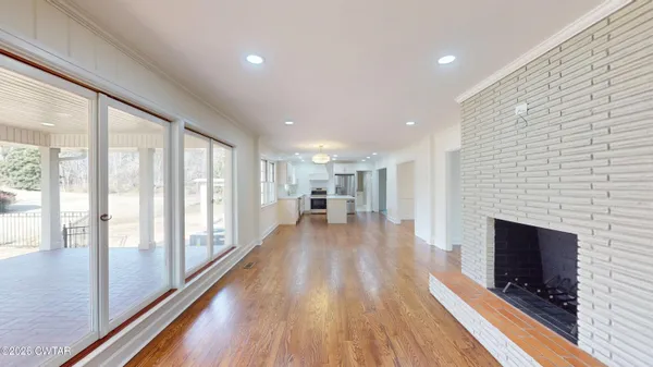 a view of a living room with a fireplace and wooden floor