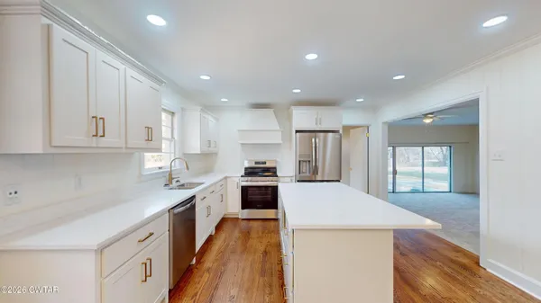 a large kitchen with stainless steel appliances granite countertop a large counter top and a stove top oven