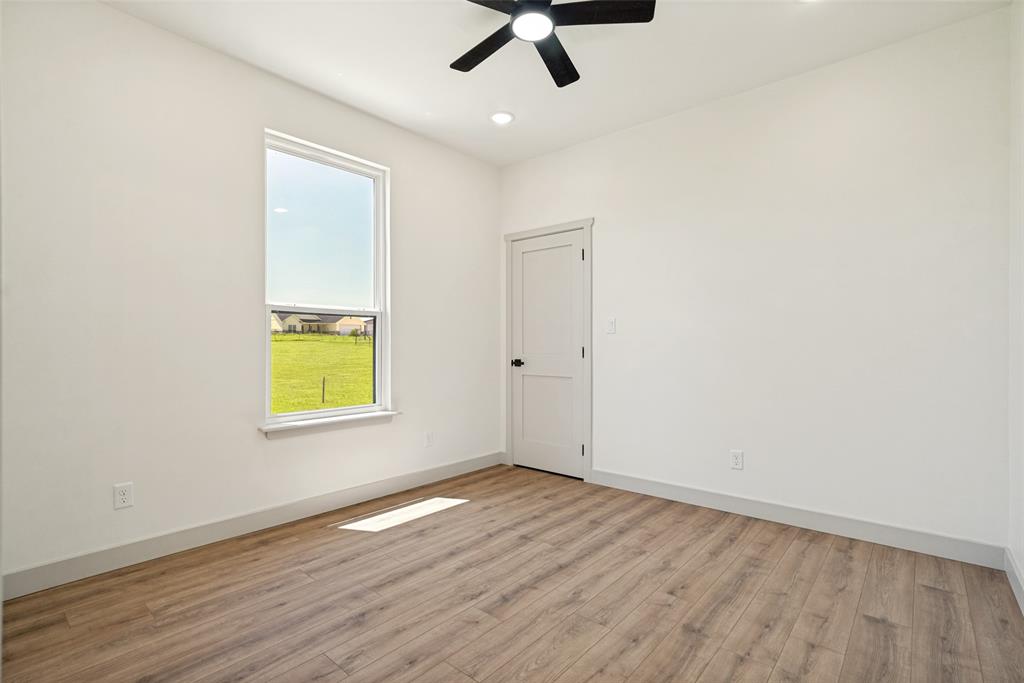 1150 Doss Road Millsap, TX 76066 - Photo 27 of 32 Bedroom 3 featuring wood-finish flooring, white walls, and a single window with a white frame