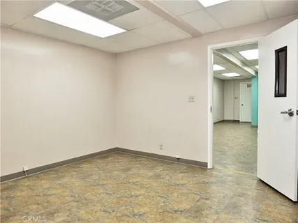 a view of a big room with wooden floor and a kitchen