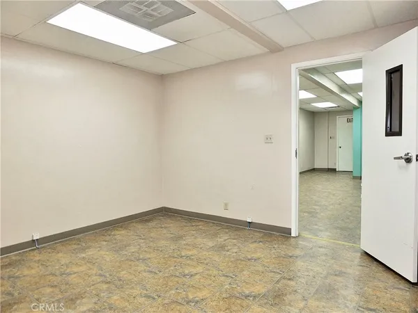 a view of a big room with wooden floor and a kitchen