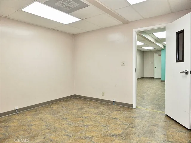 a view of a big room with wooden floor and a kitchen