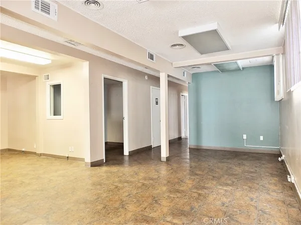 a view of empty room with window and wooden floor