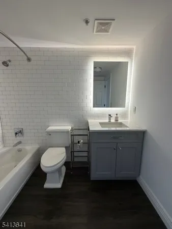 a bathroom with a sink toilet a mirror and bathtub