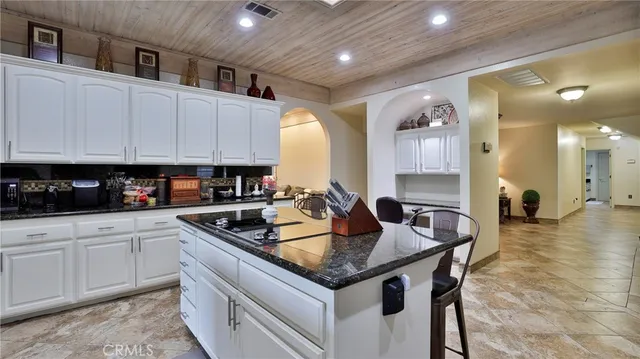 a kitchen with stainless steel appliances granite countertop a sink a stove and cabinets