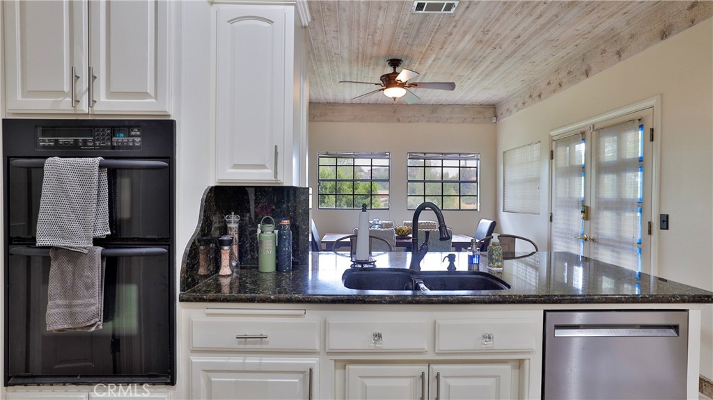 12698 La Solana Drive Redlands, CA 92373 - Photo 19 of 65 a kitchen with stainless steel appliances granite countertop a sink a stove and cabinets