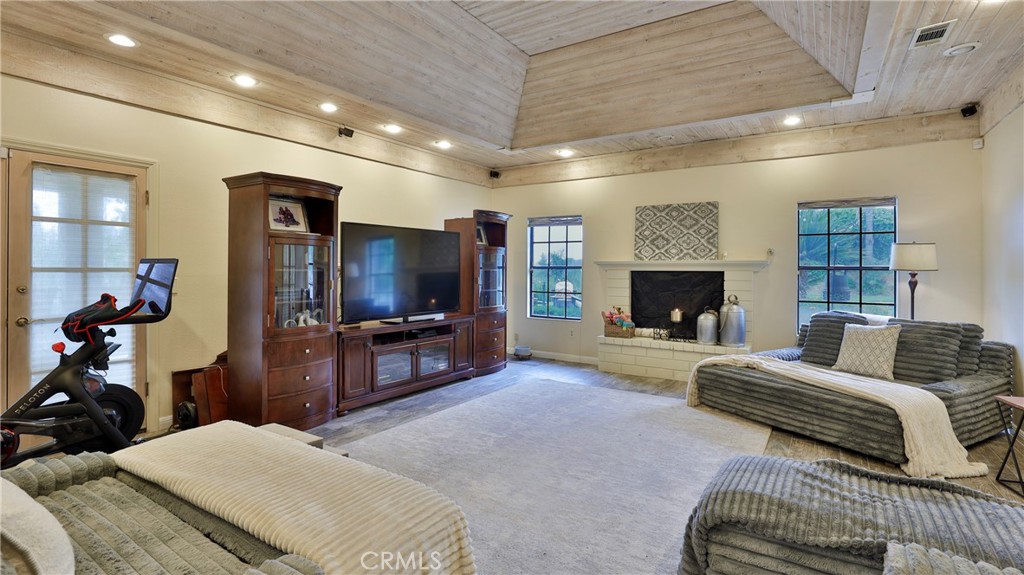 12698 La Solana Drive Redlands, CA 92373 - Photo 10 of 65 a spacious bedroom with a bed a fireplace and a television