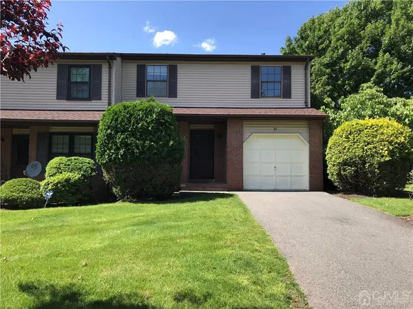 a front view of a house with a garden and yard