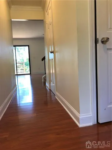 a view of hallway with hardwood floor and a window
