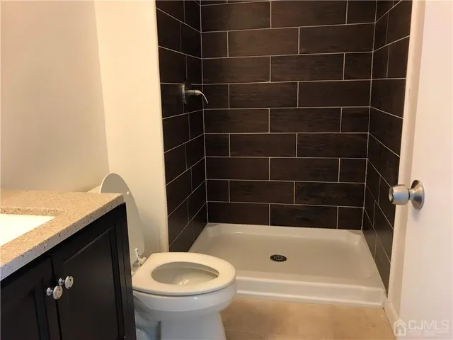 a bathroom with a granite countertop bathtub sink