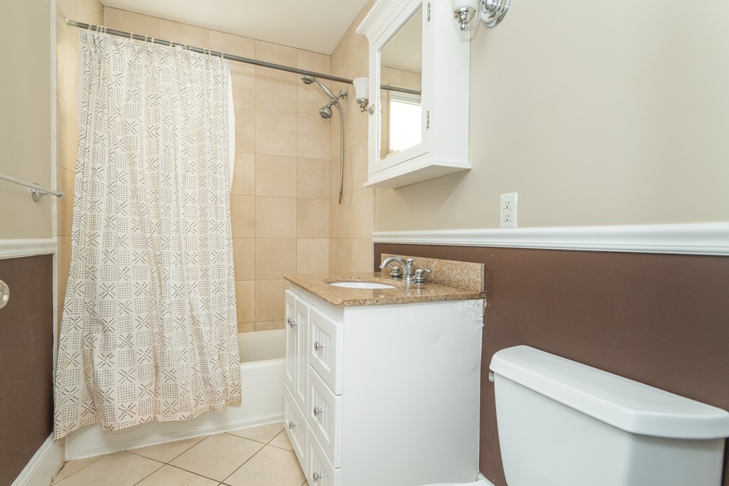 23 Hurd Road, Unit 1 Brookline, MA 02445 - Photo 9 of 12 a bathroom with a granite countertop sink a toilet and shower