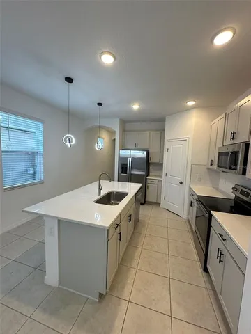 a kitchen with a sink a stove top oven and cabinets