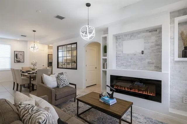 a living room with furniture chandelier and a fireplace