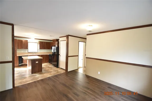 a kitchen with stainless steel appliances a refrigerator and wooden floor