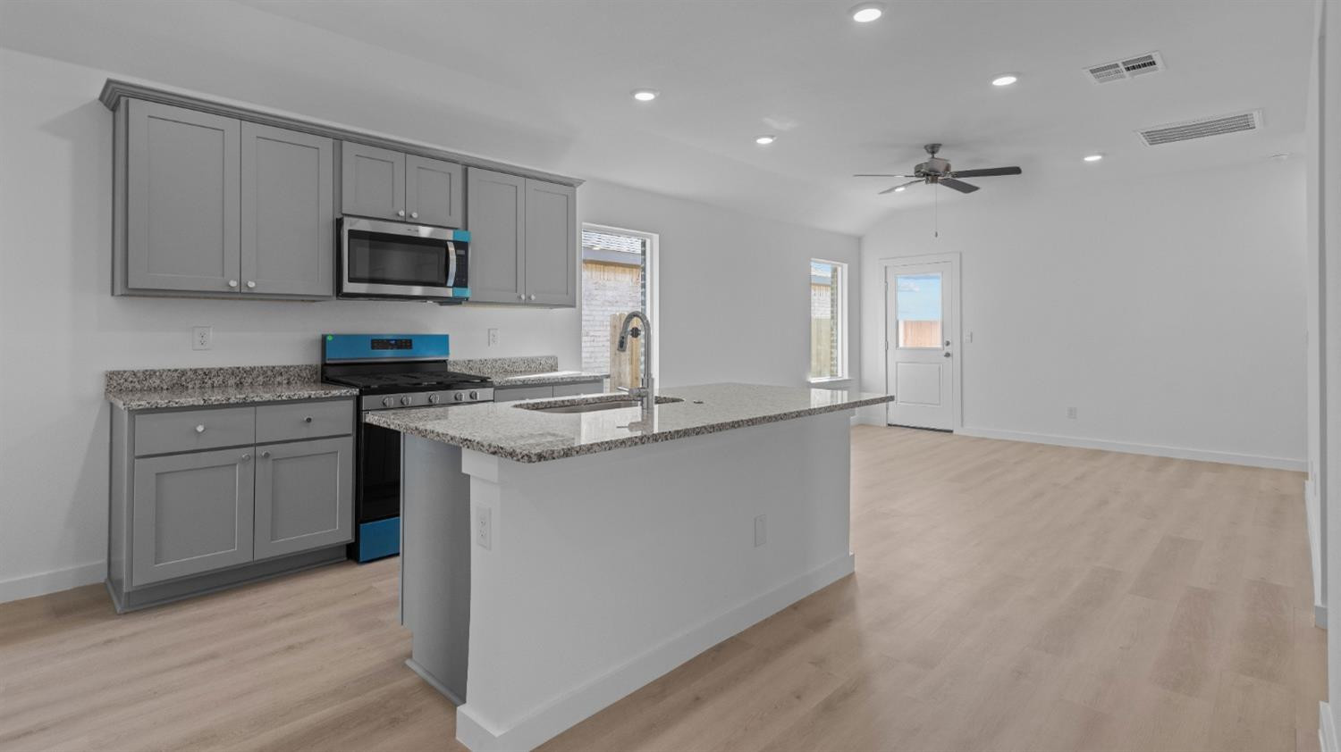 7448 8th Street Lubbock, TX 79416 - Photo 8 of 22 a kitchen with granite countertop white cabinets and stainless steel appliances