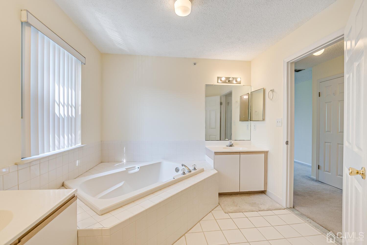 22 Prestwick Way Edison, NJ 08820 - Photo 20 of 24 a spacious bathroom with a tub sink and mirror