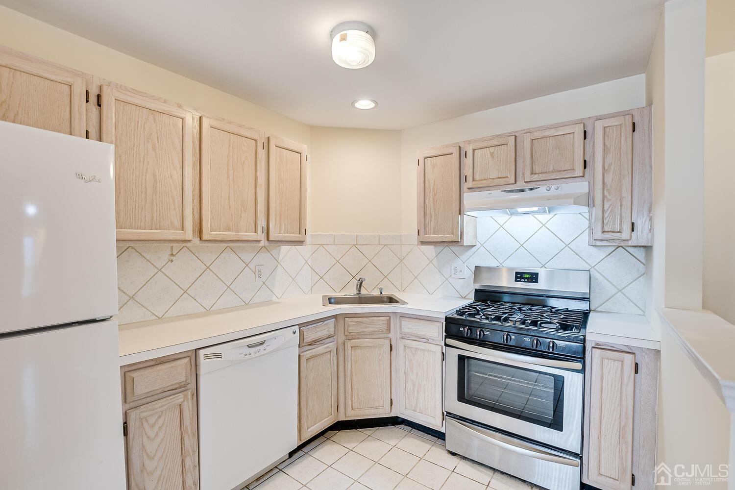 22 Prestwick Way Edison, NJ 08820 - Photo 10 of 24 a kitchen with white cabinets and appliances