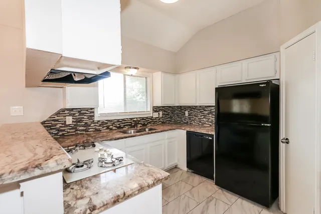 a kitchen with stainless steel appliances granite countertop a stove and a refrigerator