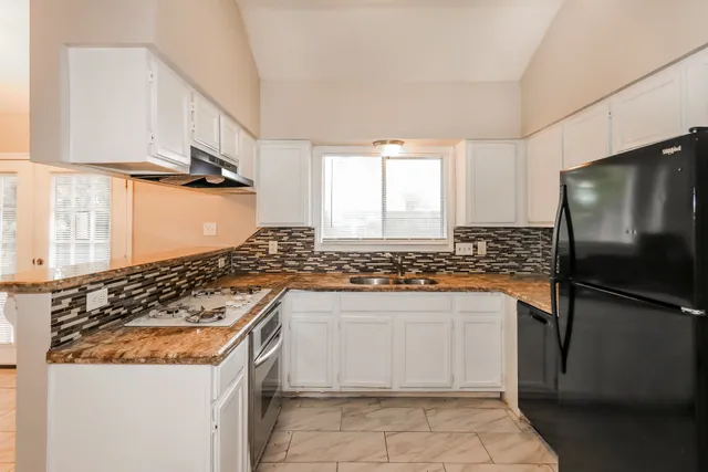 a kitchen with stainless steel appliances granite countertop a stove and a refrigerator