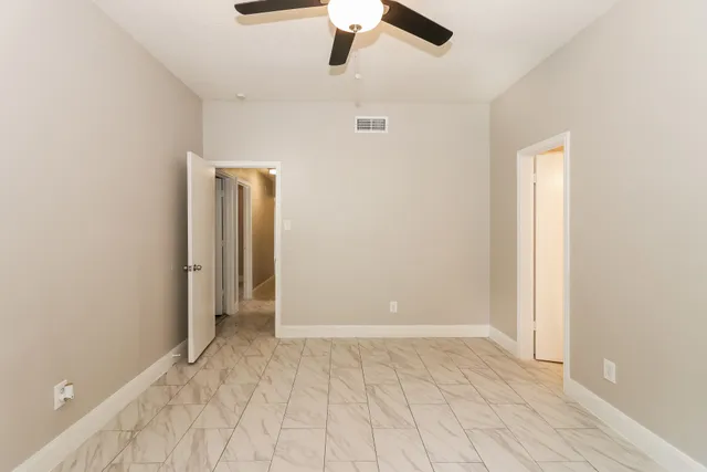 an empty room with closet and windows
