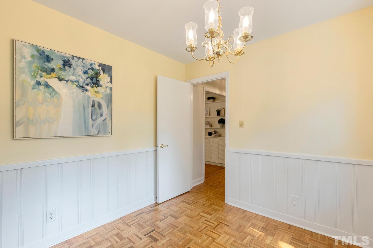 5004 Rembert Drive Raleigh, NC 27612 - Photo 11 of 61 a view of a hallway with wooden floor and a chandelier