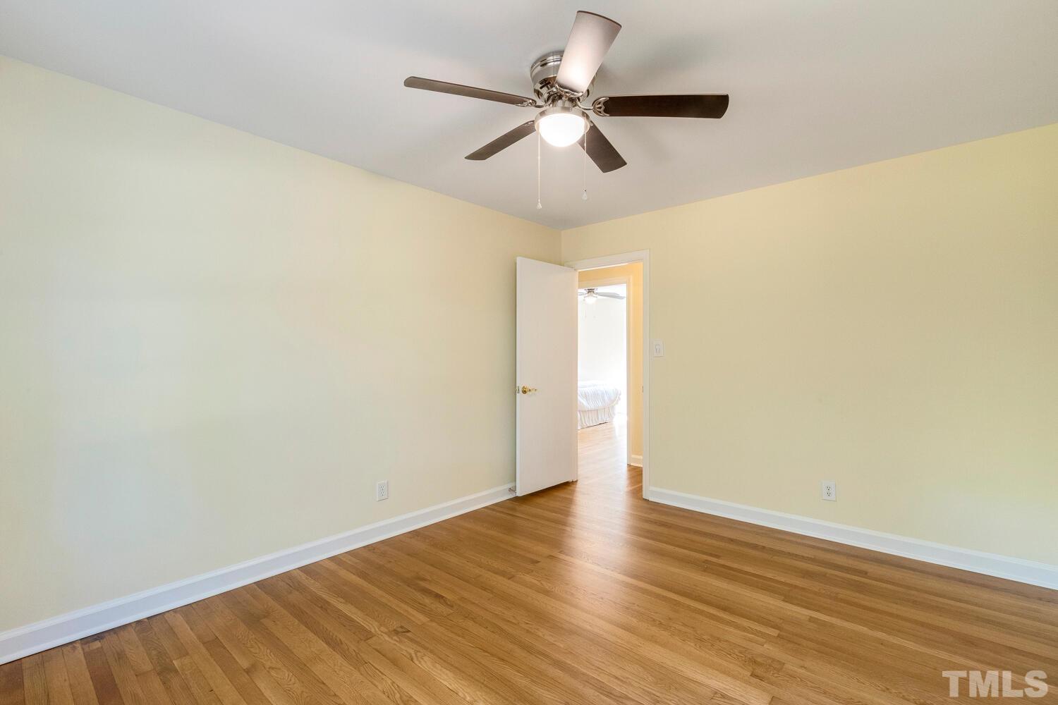 5004 Rembert Drive Raleigh, NC 27612 - Photo 30 of 61 an empty room with wooden floor and a ceiling fan