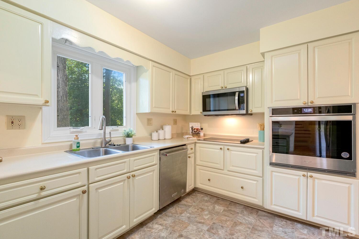5004 Rembert Drive Raleigh, NC 27612 - Photo 5 of 61 a kitchen with stainless steel appliances granite countertop a stove a sink and a microwave