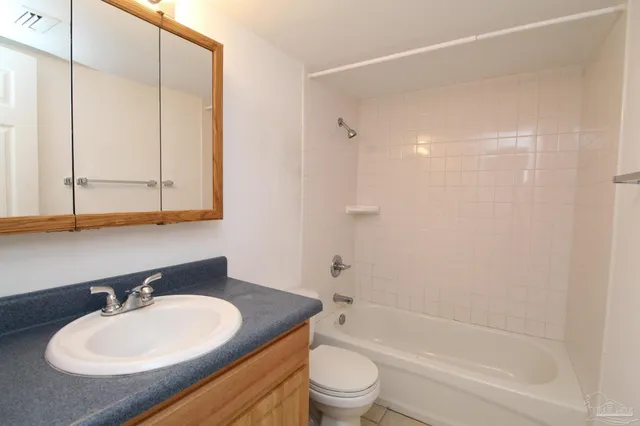 a bathroom with a granite countertop sink toilet a mirror and bathtub