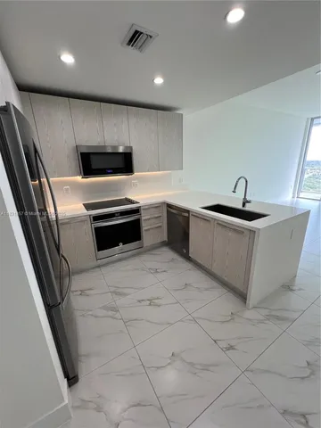 a kitchen with a sink stove and cabinets