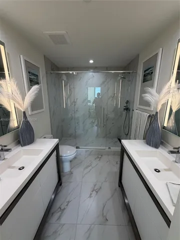 a bathroom with a granite countertop sink mirror and shower