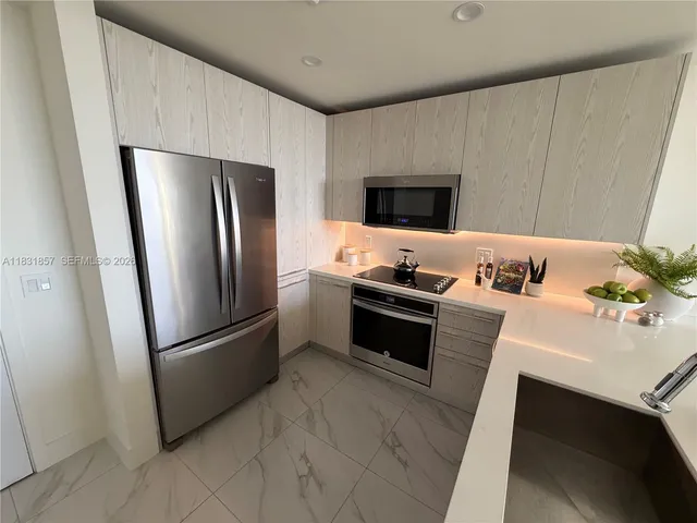 a kitchen with stainless steel appliances a refrigerator a stove a sink and a refrigerator