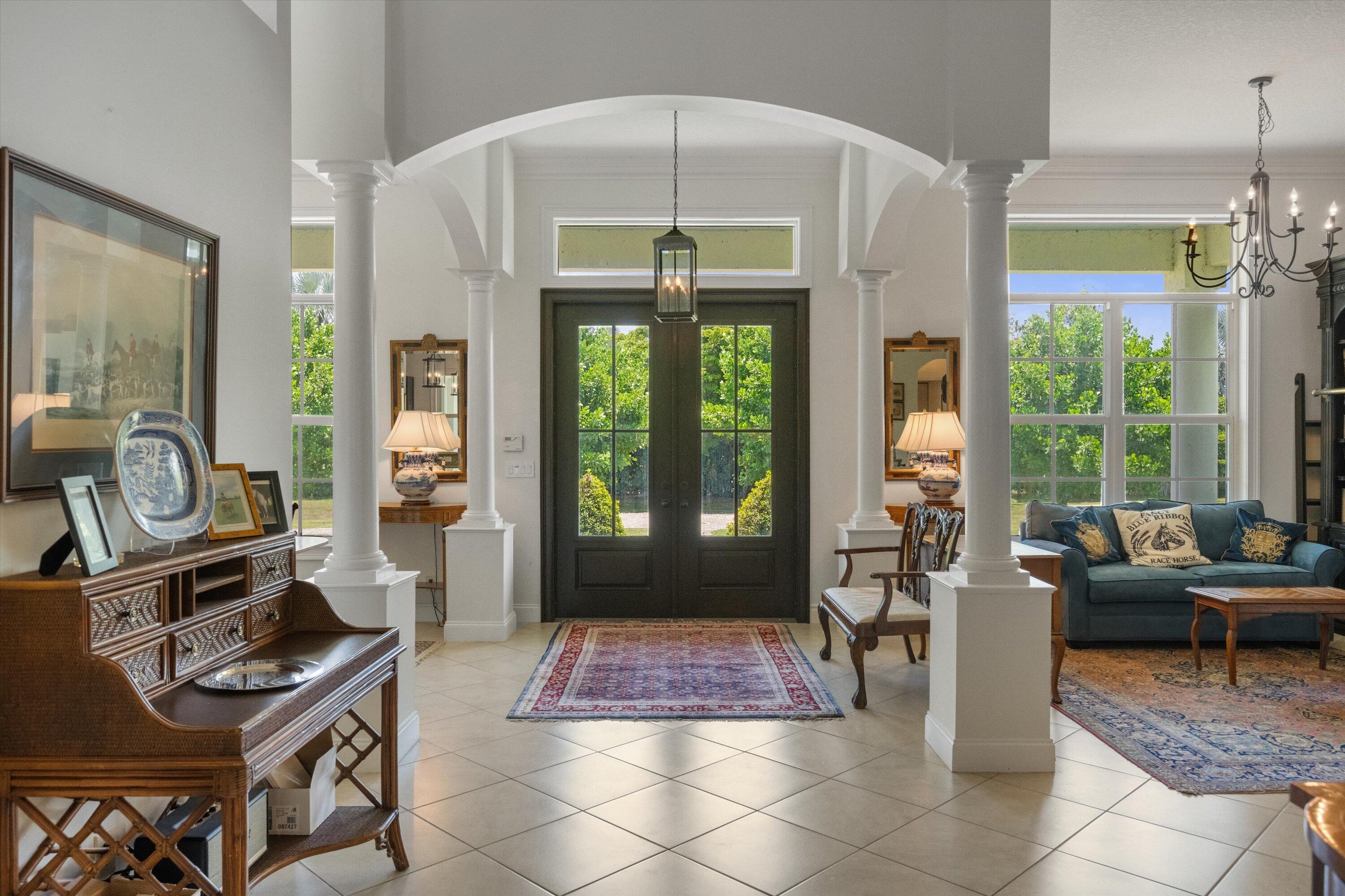 19986 Black Falcon Road Loxahatchee, FL 33470 - Photo 16 of 105 a living room with furniture a flat screen tv and a floor to ceiling window
